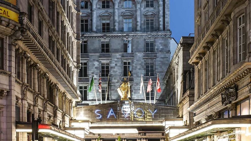 The Savoy entrance at night with flags