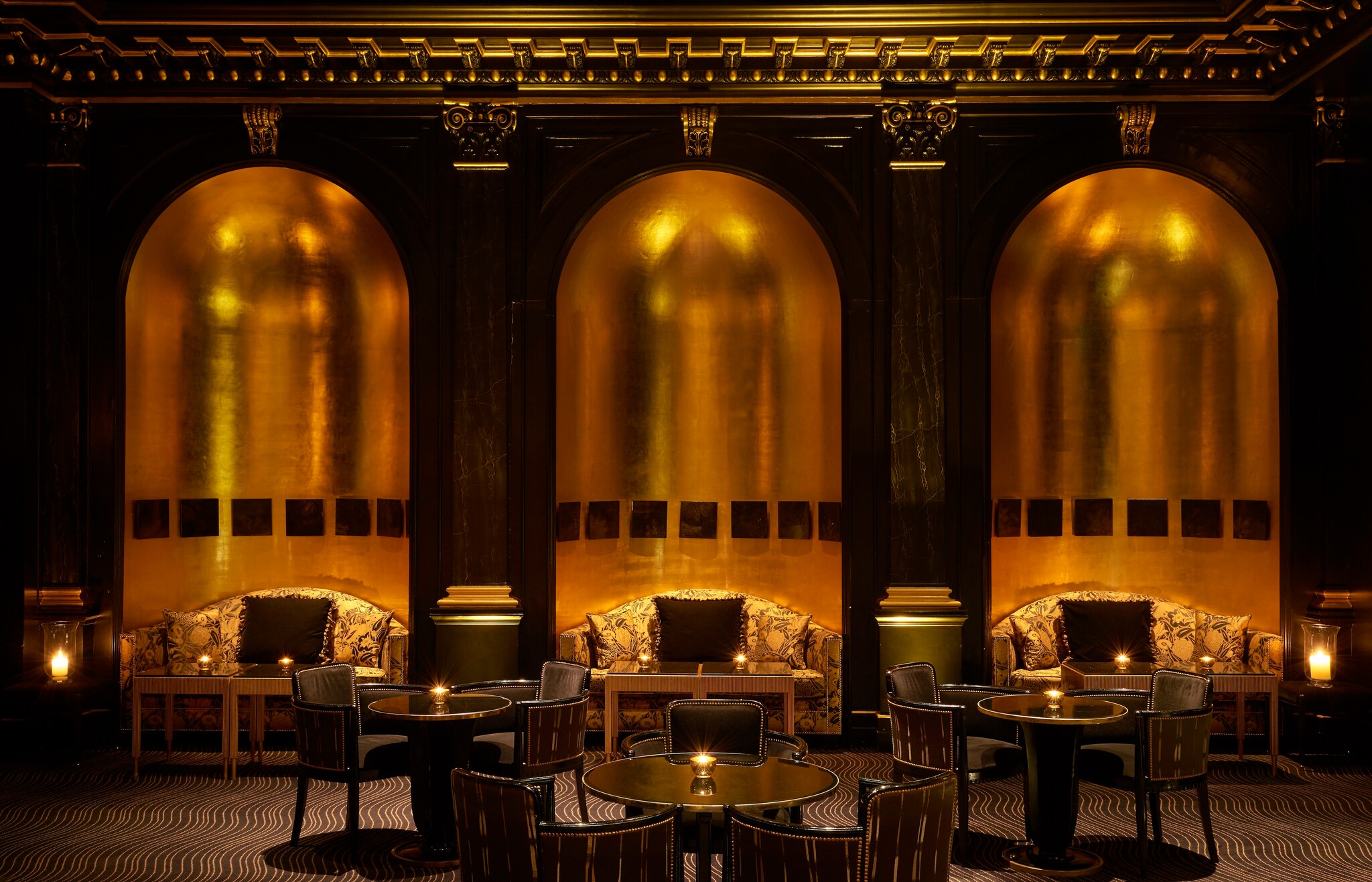 In the Beaufort Bar, booths along the wall are nestled in metallic gold recesses like giant bells, with plush couches to sit in.