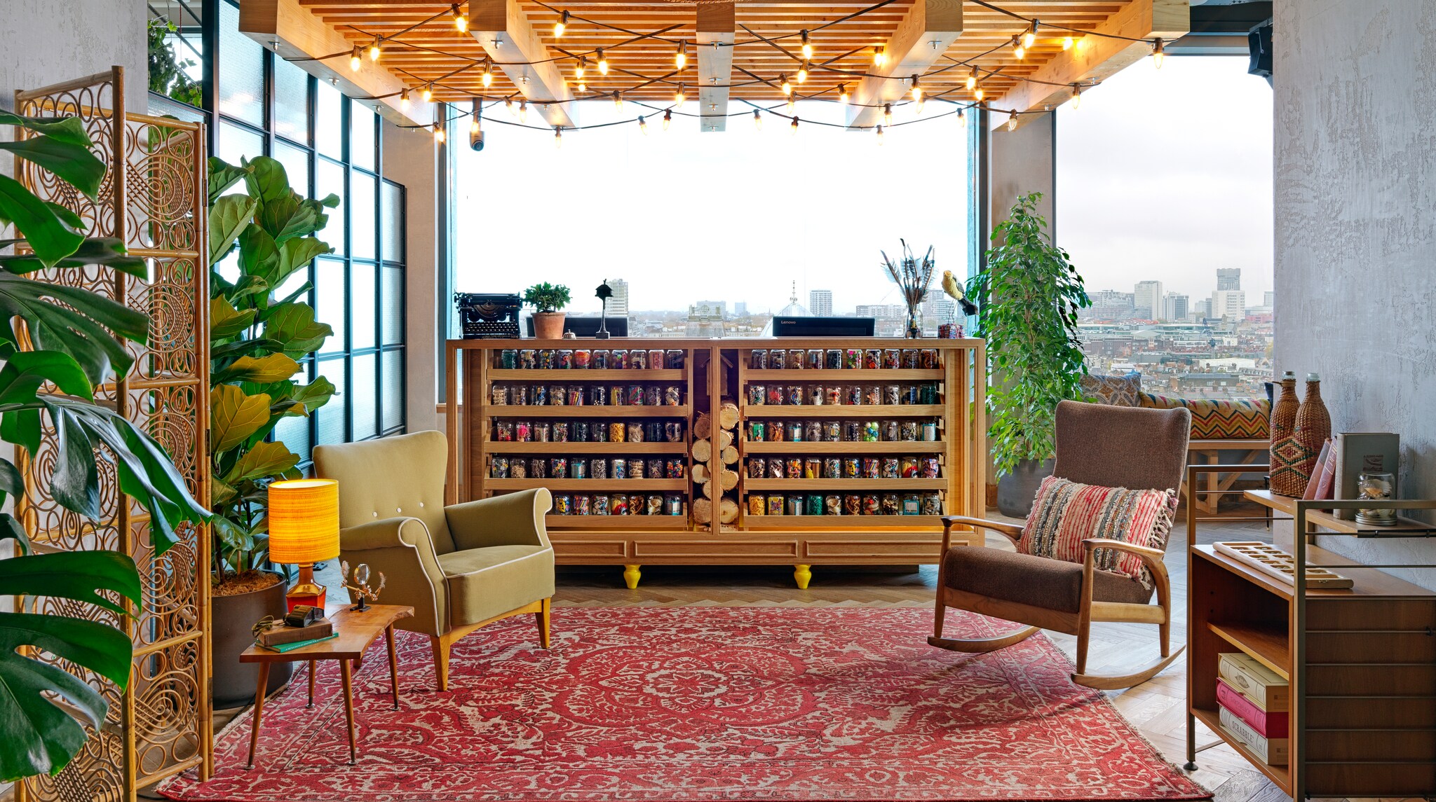 The reception area evokes the upscale outdoors with strings of lights across the ceilings, ample potted plants, and wooden furniture. 
