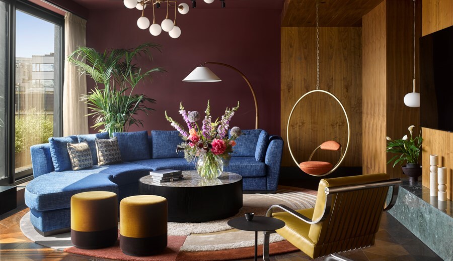 The Penthouse Lounge Area features geometric furniture, including a circular couch, chandelier, and hanging chair, and adjoins a patio