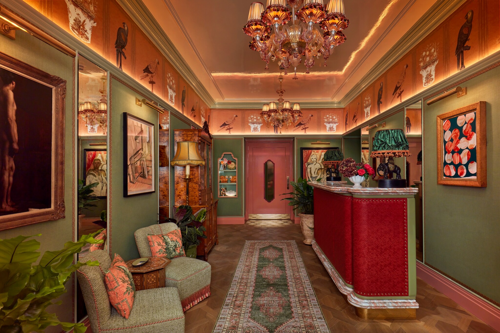 The hotel lobby is decorated in a maximalist style, with bright paint, ornate antique furniture, and art on every wall.