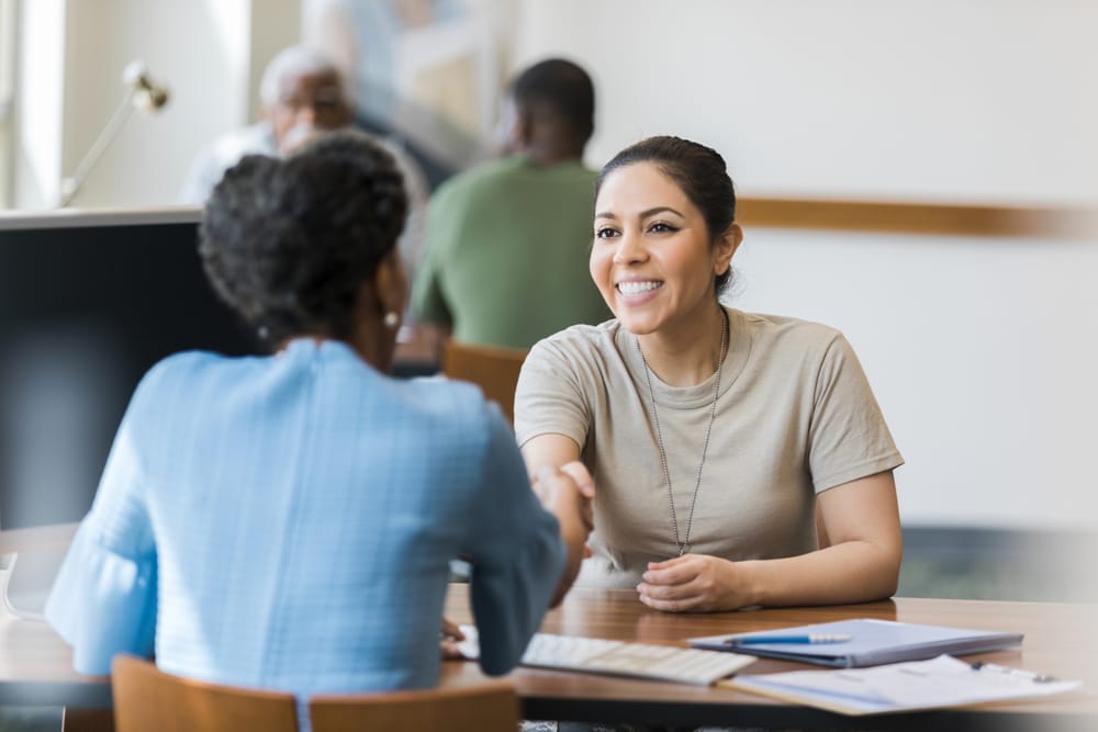 A woman shakes the hand of a loan officer after their meeting A woman shakes the hand of a loan officer after their meeting