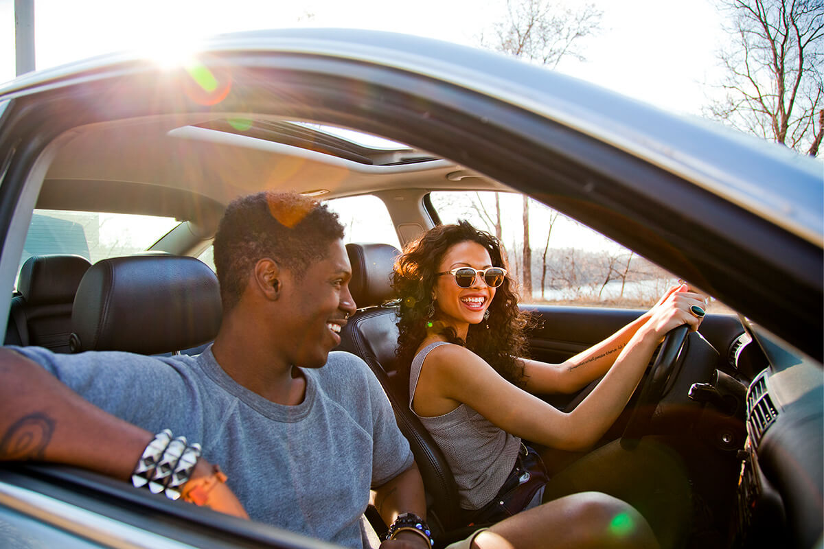 Woman and man are driving in a car and smiling Woman and man are driving in a car and smiling